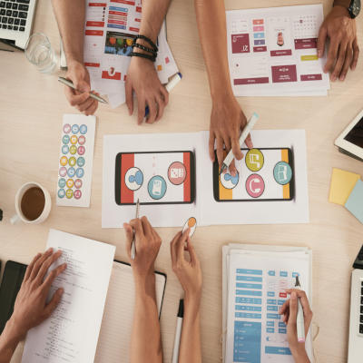 People around a desk, discussing about a mobile product.